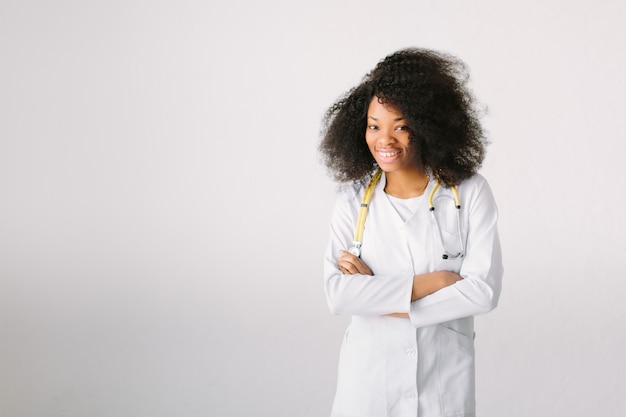 Afrikaanse artsenvrouw die op witte achtergrond met een stethoscoop wordt geïsoleerd