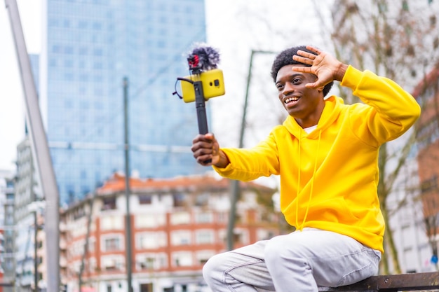 Afrikaanse contentmaker die naar de camera zwaait om een video op te nemen