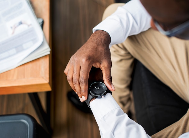 Afrikaanse etniciteit man zit kijken naar een horloge