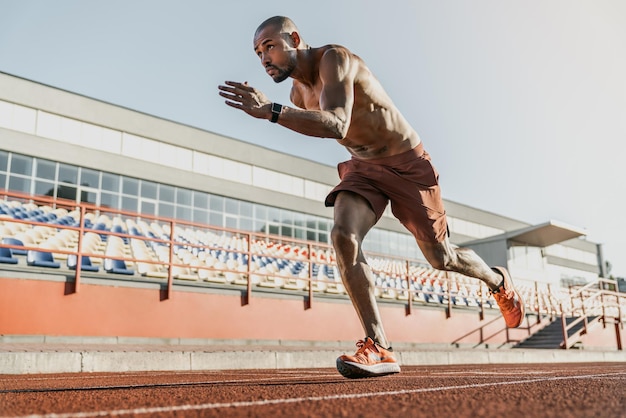 Afrikaanse hardloperatleet die zijn sprint begint op de atletiekbaan in het stadion