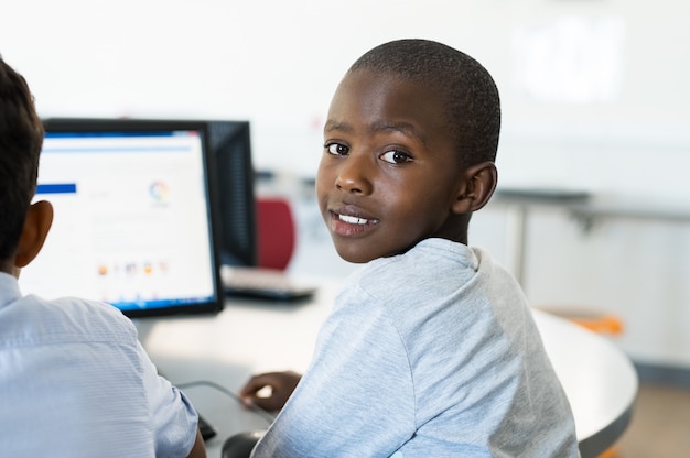 Afrikaanse jongen die computer met behulp van op school