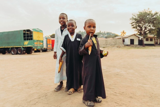 Afrikaanse kinderen genieten van hun gekookte maïs buitenfoto Premium Foto