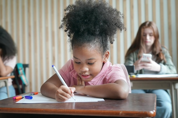 Afrikaanse kinderen tekenen en huiswerk in de klas jong meisje gelukkig grappige studie op school