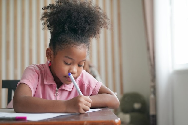 Afrikaanse kinderen tekenen en huiswerk in de klas jong meisje gelukkig grappige studie op school