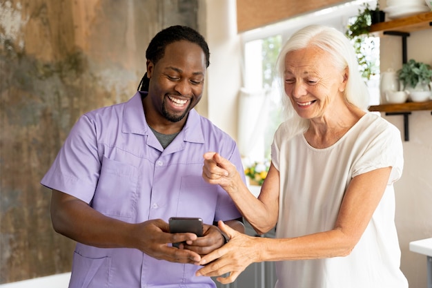 Afrikaanse maatschappelijk werker die een oudere vrouw helpt