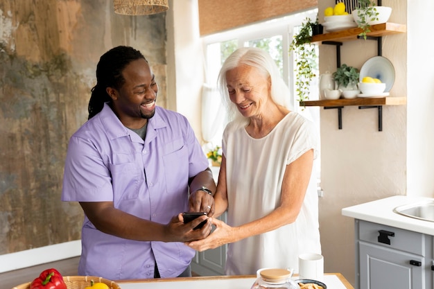 Afrikaanse maatschappelijk werker die een oudere vrouw helpt