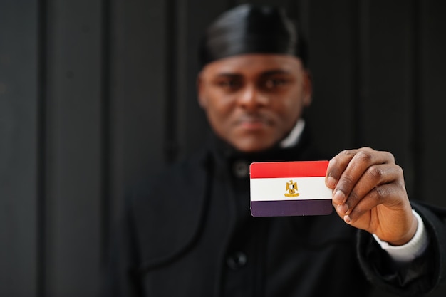 Afrikaanse man draagt zwarte durag greep Egypte vlag bij de hand geïsoleerde donkere achtergrond