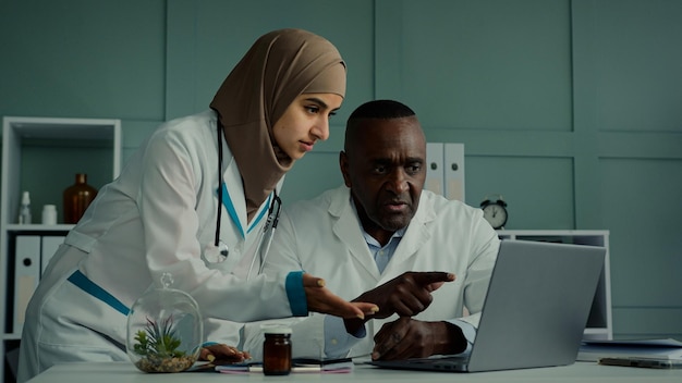 Afrikaanse man en Arabische vrouw twee professionele artsen praten over gezondheidszorg