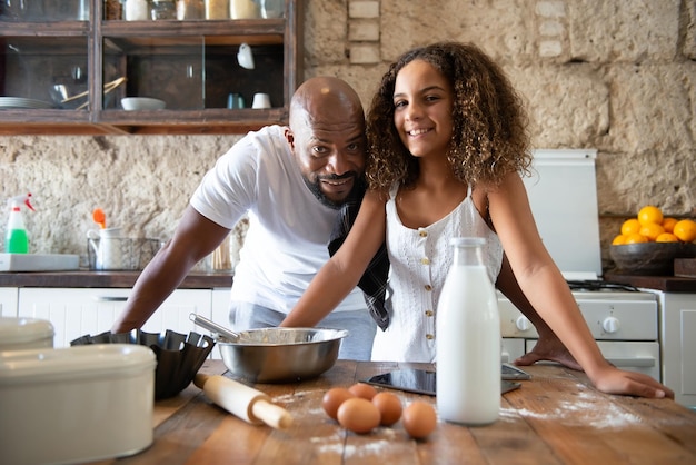 Afrikaanse man met zijn dochter in de keuken van zijn huis