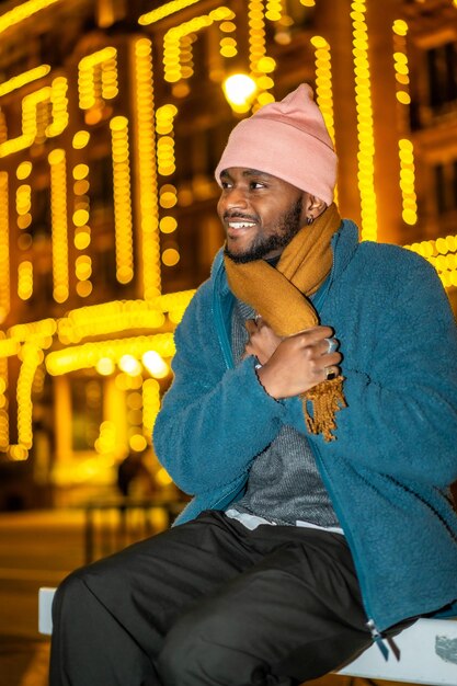Afrikaanse man voelt zich koud tijdens de kerstnacht in de stad