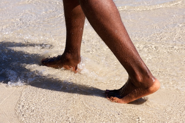 Afrikaanse mensenvoeten die op het strand lopen