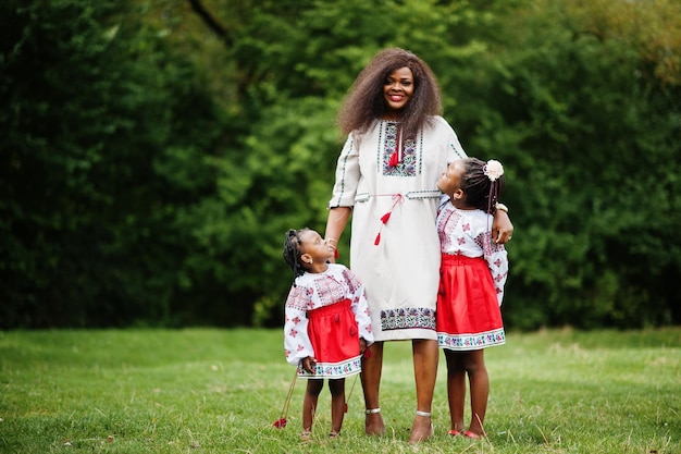 Afrikaanse moeder met dochters in traditionele kleding in het park.