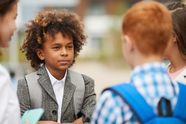 Afrikaanse schooljongen met vrienden buitenshuis