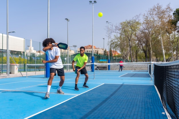 Afrikaanse sportieve vrienden die samen buiten pickleball spelen