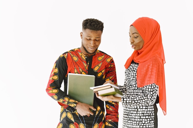 Afrikaanse studenten. Jongeren in traditionele Nigeriaanse kleding. Boeken vasthouden. Studieconcept.