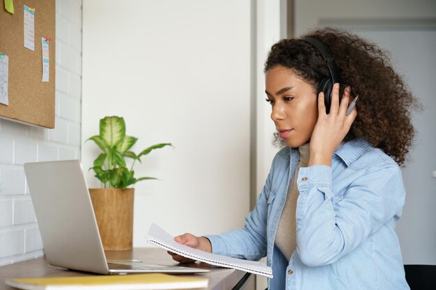 Afrikaanse tiener meisje college student scholier externe werknemer leren studeren thuis bureau kijken naar educatieve training klasse maken videoconferentiegesprek op computer afstand e-learning