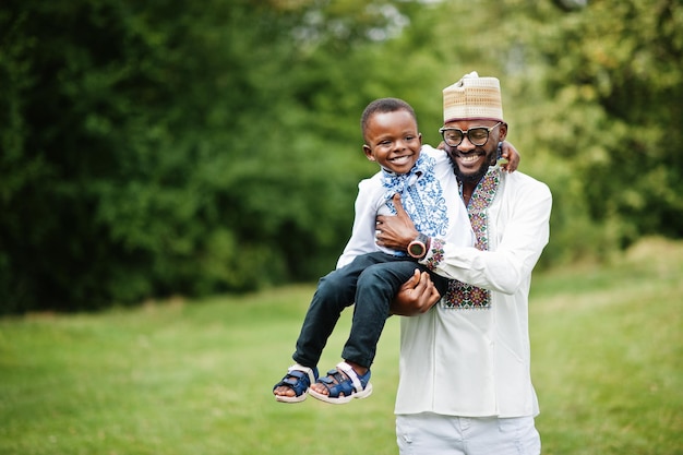 Afrikaanse vader met zoon in traditionele kleding bij park