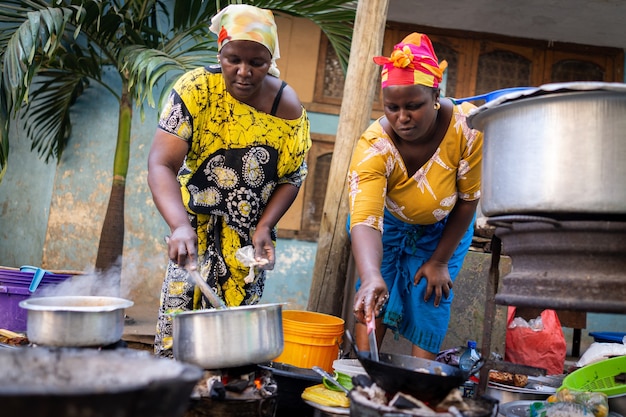 Afrikaanse vrouw die traditioneel voedsel kookt op straat