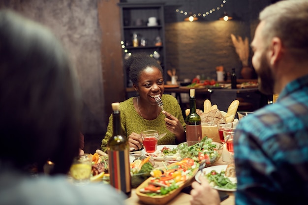 Afrikaanse vrouw genieten van diner met vrienden