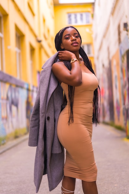 Afrikaanse vrouw in een crèmekleurige jurk op een straat in de stad