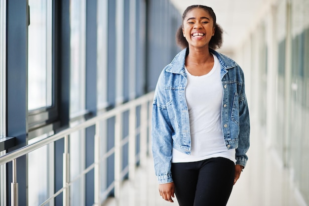 Afrikaanse vrouw in jeans jasje poseerde binnen.