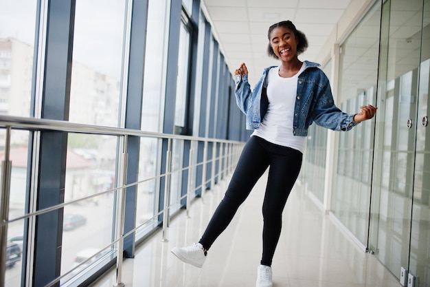 Afrikaanse vrouw in jeans jasje poseerde binnen.