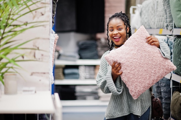 Afrikaanse vrouw kiest kussen voor haar appartement in een moderne woninginrichtingswinkel