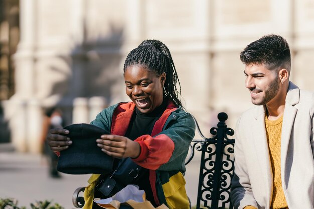 Afrikaanse vrouw met een verbaasd gezicht met een hoed die ze net als cadeau heeft gekregen naast een man