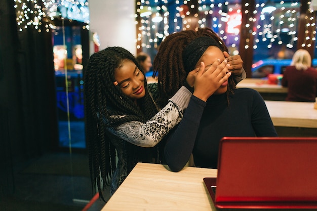 Afrikaanse vrouw zit achter haar vriend en houd haar ogen dicht