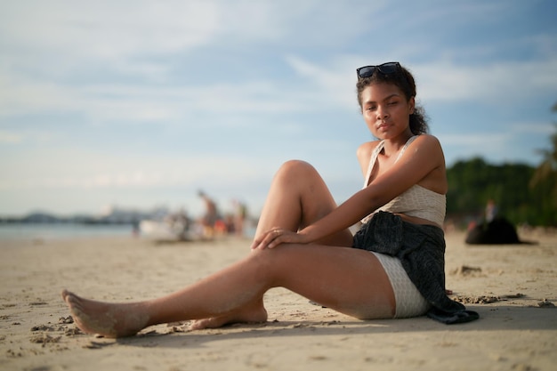 Afrikaanse vrouw zitten op het strand portret sexy afrikaanse dame reizen ping en ontspannen in de zomer met tropische natuur