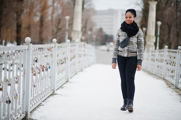 Afrikaanse vrouwenkleding in zwarte sjaal stelt in de winterdag