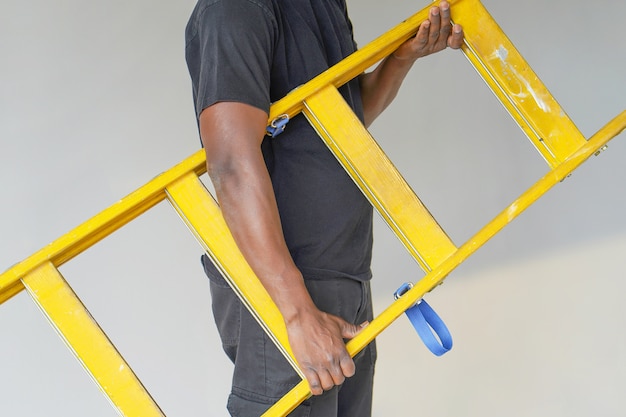Afrikaanse werknemer met houten ladder