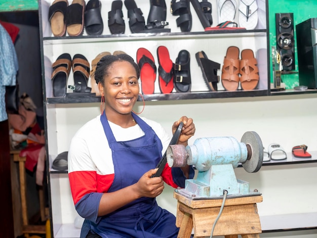 Afrikaanse zakenvrouw die schoenen binnenshuis vasthoudt