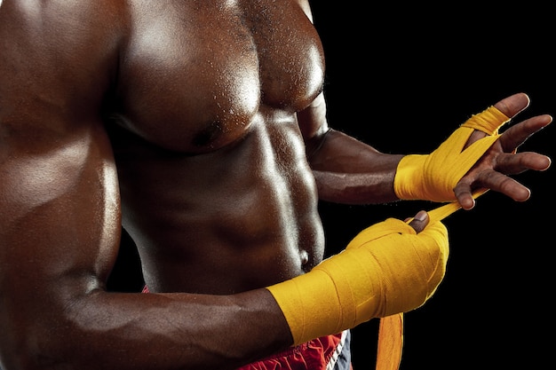 아프리카 계 미국인 권투 선수가 노란색 붕대로 손을 감싸고 있습니다