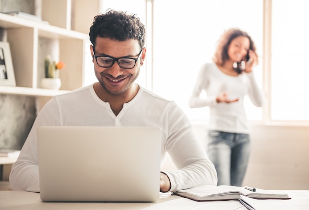 Afro American businessman is using a laptop at home.