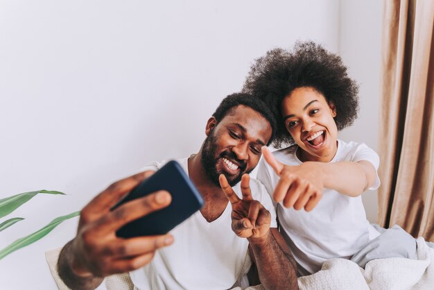 Afro american couple in bed  Real beautiful and cheerful pair of lovers at home