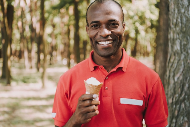 Afro American Guy Is Eating Ice Cream In Forest.