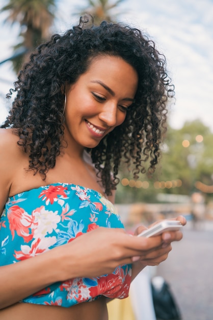 Afro American latin woman using mobile phone.