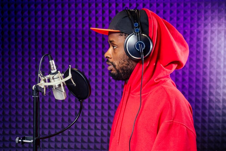afro american man headphones in a cap and a hood sunglasses recording hip hop song track.