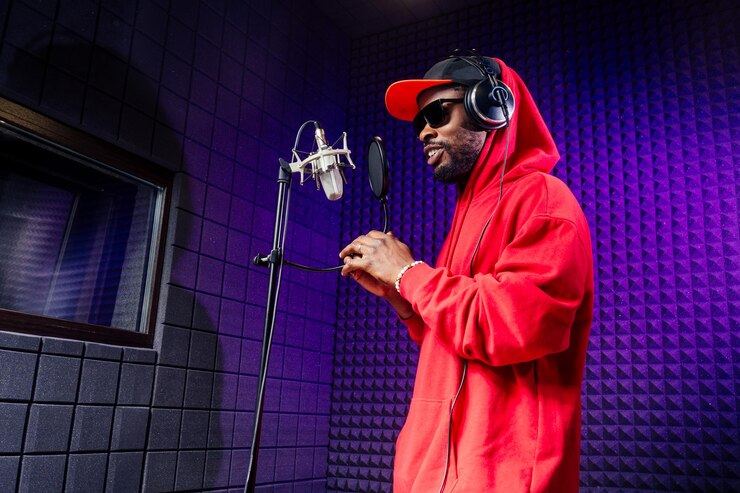 afro american man headphones in a cap and a hood sunglasses recording hip hop song track.