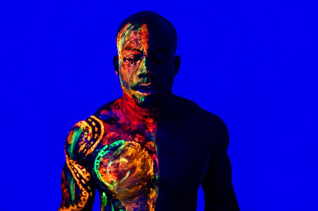 Afro american man with UV body art posing in studio