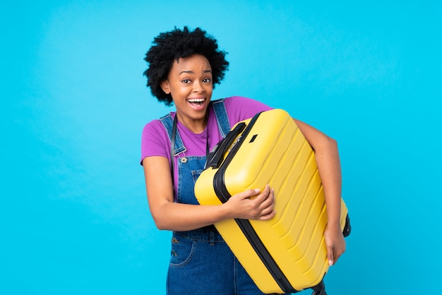 Afro American traveler woman  over blue wall