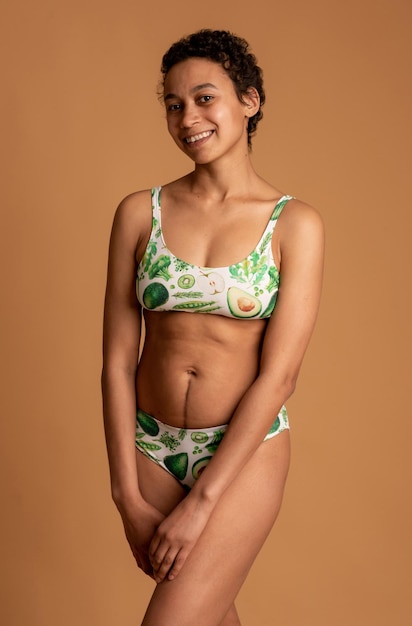 Afro american woman in lingerie posing on a pink background body positive