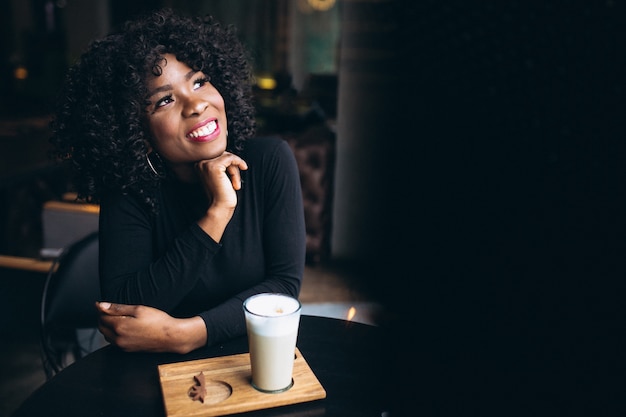 Afro american woman with coffee sitting in a cafe