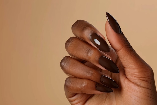 Photo an afro american womans hand with a brown nail polish on the long almond shaped nails