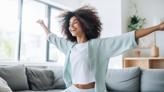 Afro american young woman dancing on the sofa at home