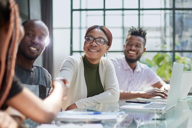 Afro-Amerikaans HR-team verwelkomt vrouwelijke sollicitant bij een sollicitatiegesprek