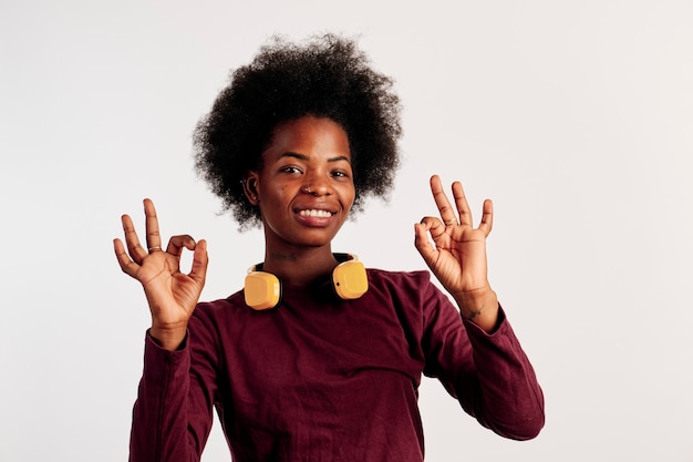 Afro-Amerikaans meisje in bruine trui poseert met haar handen