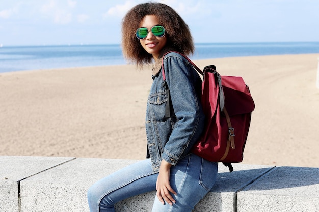 Afro-Amerikaans meisje in zonnebril poseren buitenshuis Casual gekleed met kort volumineus haar