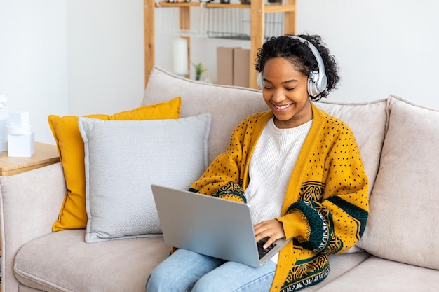 Afro-amerikaans meisje met behulp van laptop thuis kantoor kijken naar scherm typen chatten lezen schrijven e-mail Jonge vrouw met virtuele vergadering online chat video-oproep conferentie Werk leren vanuit huis